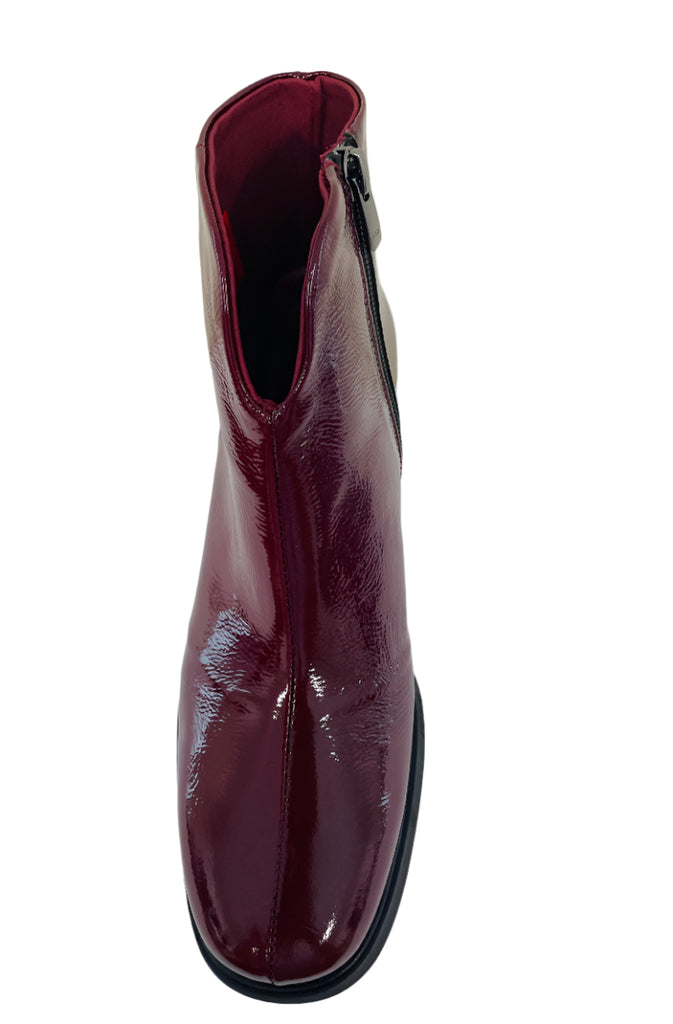 Patent leather ankle boot on a white background