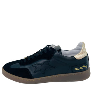 Black sneaker with tan sole on a white background