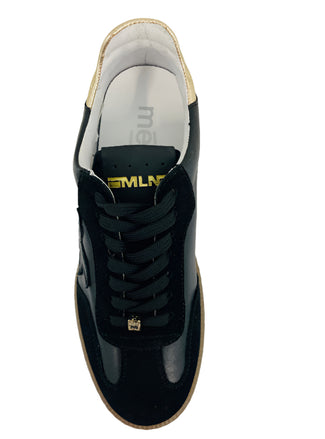 Black sneaker with tan sole on a white background