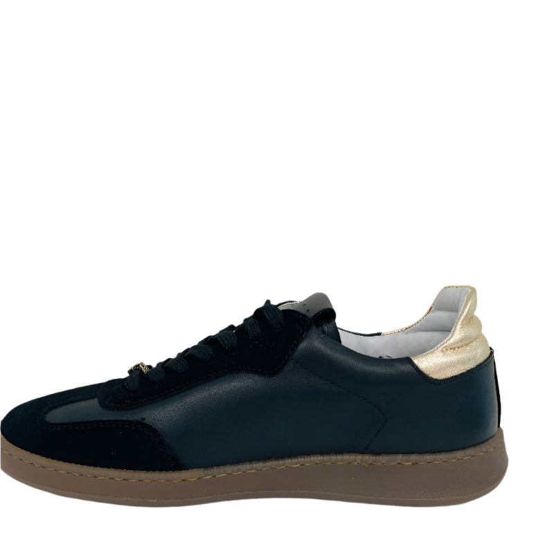 Black sneaker with a white sole on a light gray background