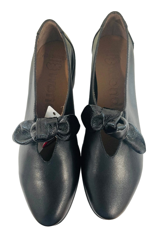 Black shoes with velvet bows on a white surface
