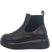 Load image into Gallery viewer, Black Chelsea boot leaning against a white wall.

