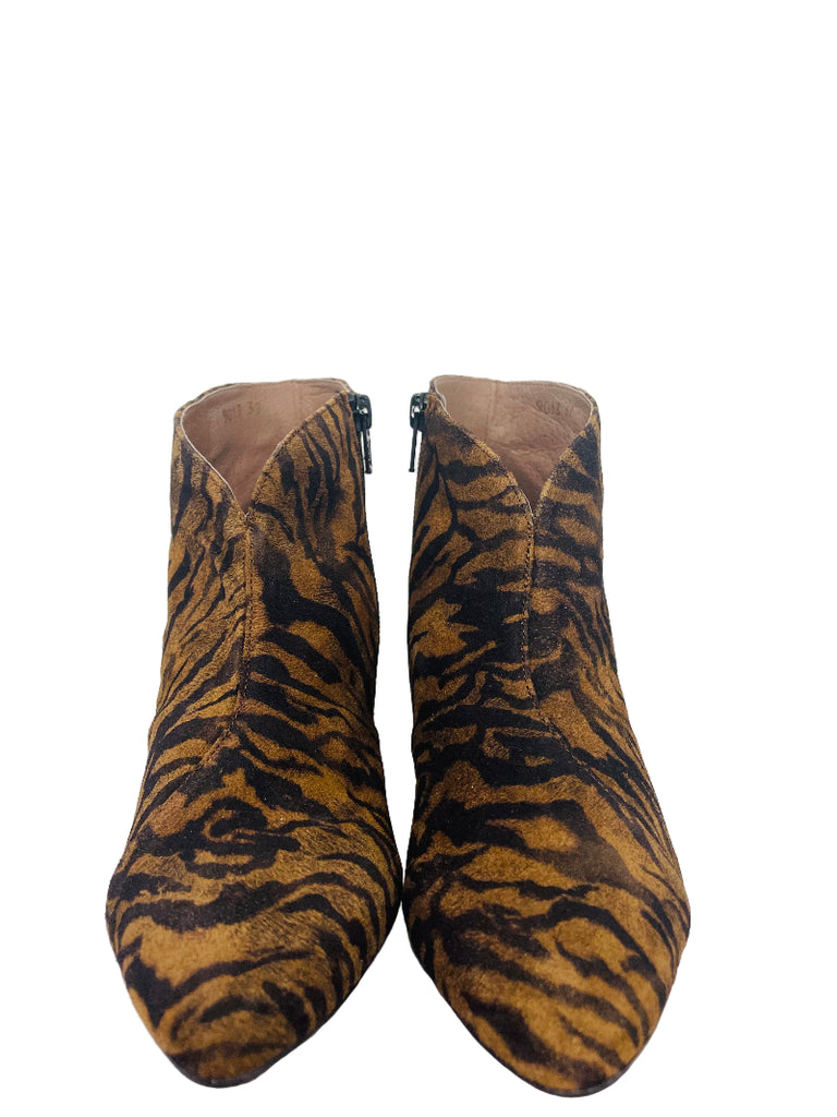 Pair of tiger striped ankle boots on a white surface with a neutral background