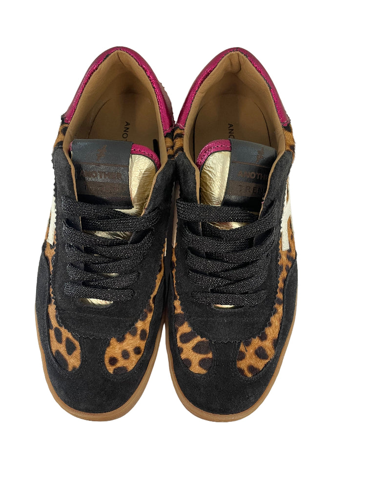Black sneakers with leopard print soles on a white surface