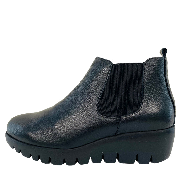 Black Chelsea boot on a light gray background