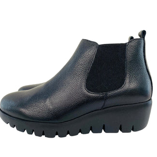 Black Chelsea boot on a light gray background