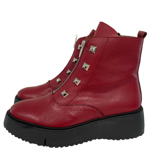 Red ankle boot with decorative studs on a light background