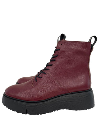 Maroon boot with black sole on a light gray background