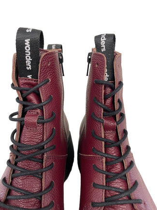 Maroon boot with black sole on a light gray background
