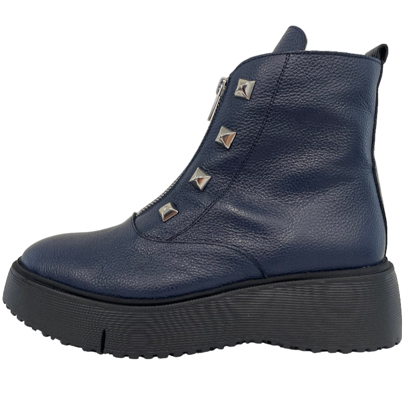 Blue ankle boot with studded details on a light gray background