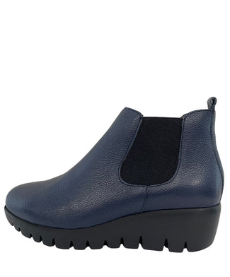Blue slip-on shoe with black sole on a light gray background