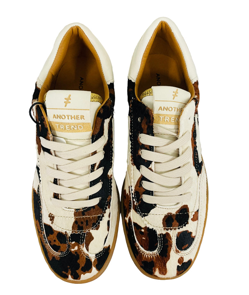 Pair of leopard print sneakers with white laces on a light background