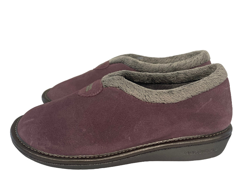 Pair of maroon slippers with gray soles hanging on a white wall.