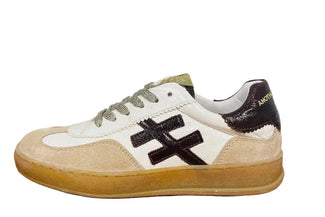 White sneaker with black logo on a wooden surface