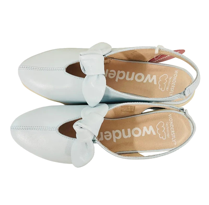 Light blue shoes with bows on a wooden surface