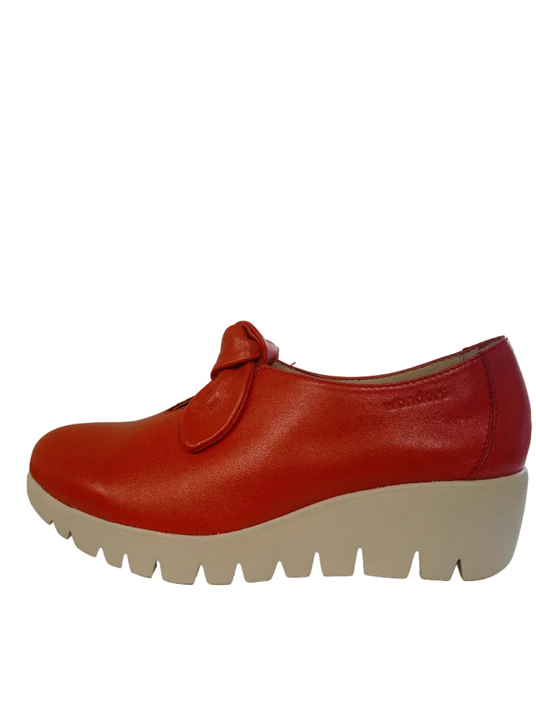 Red shoe with a white sole on a white surface