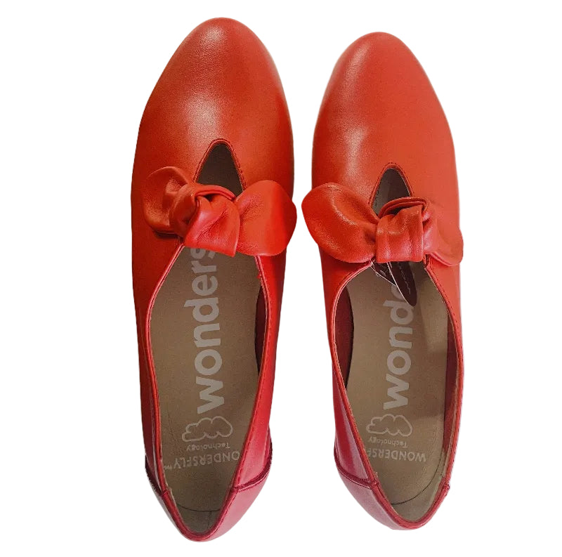Red shoes with bow details on a white surface
