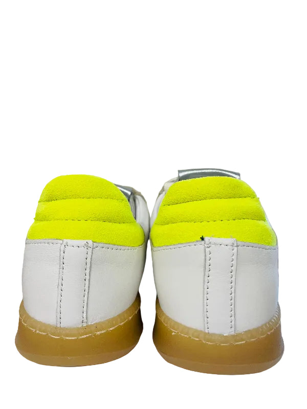 White sneakers with bright yellow soles on a white surface.