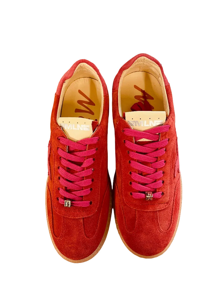 Red sneakers with pink laces on a white surface