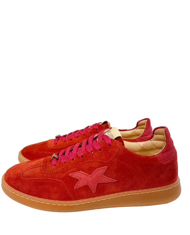 Red sneakers with a pink star on a white surface