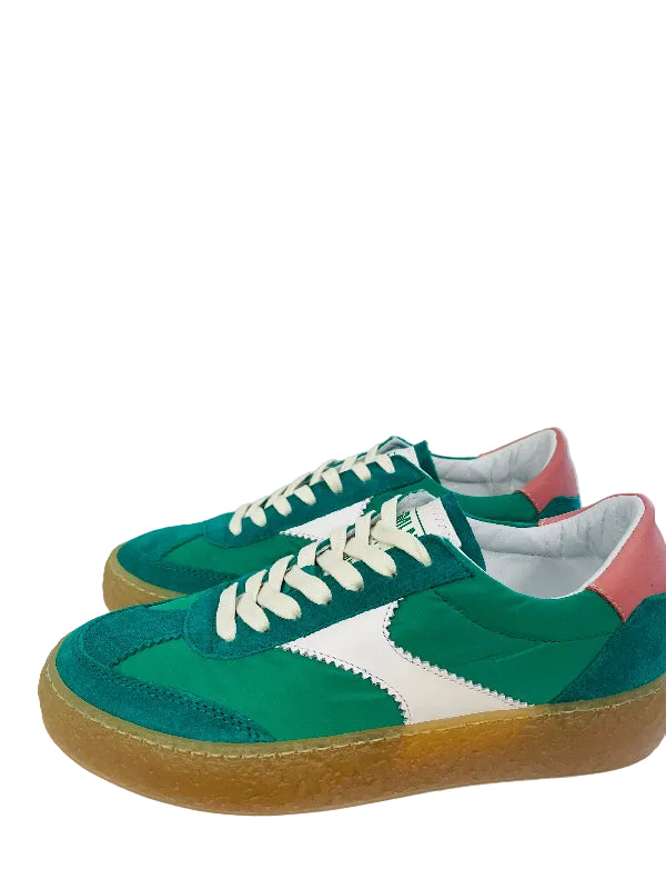 Colorful sneakers with green, white, and pink design on a wooden surface.