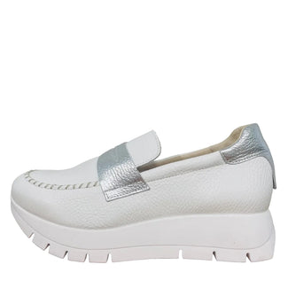 White shoe with silver accents on a wooden surface