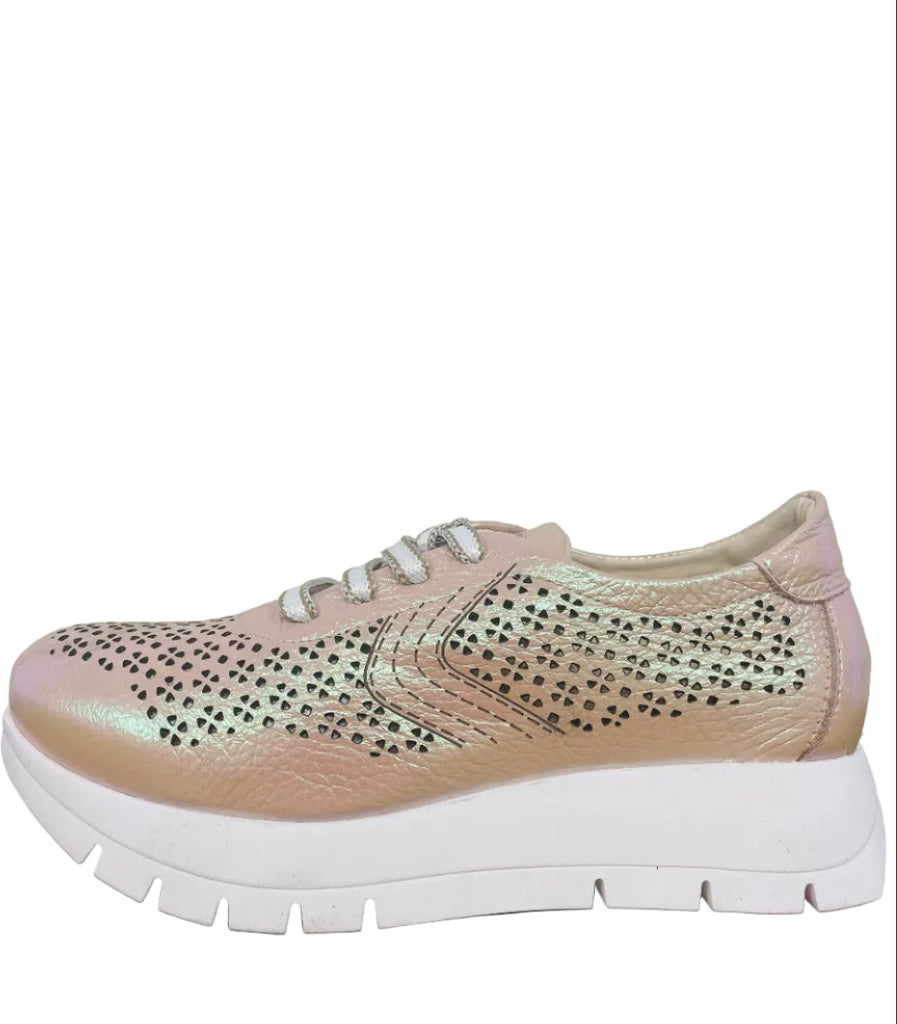 Pink sneaker with rhinestone details on a wooden surface
