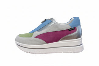 Multicolored shoe with a white sole on a wooden floor.