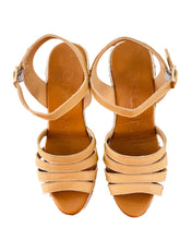 Load image into Gallery viewer, Pair of beige sandals on a wooden surface with a tiled wall in the background
