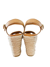 Load image into Gallery viewer, Pair of beige wedge sandals with woven sole on a wooden surface.
