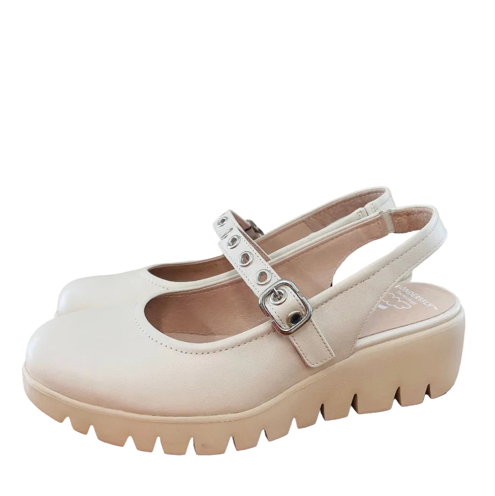 White platform shoe with a strap on a wooden surface