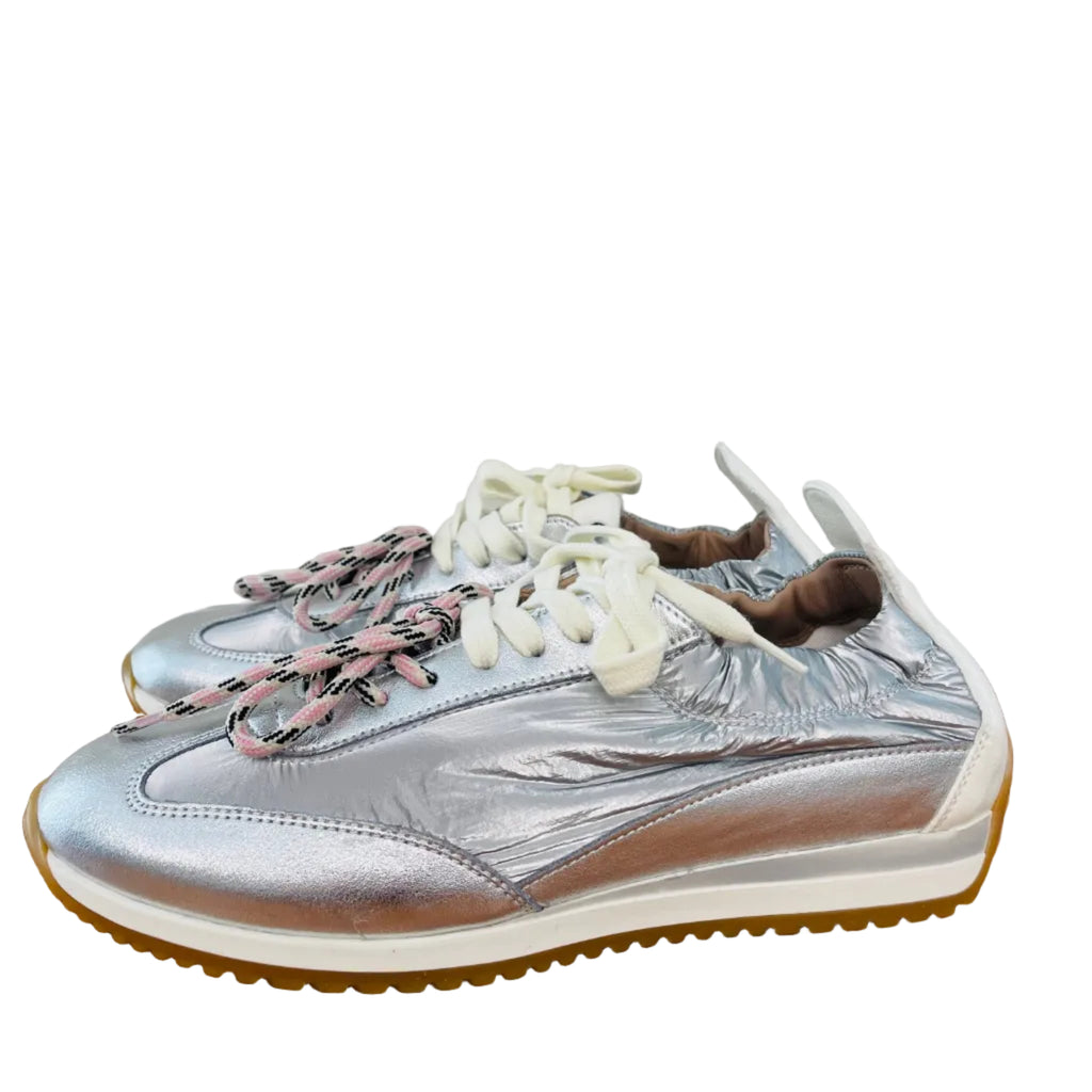 Silver sneaker with multicolor laces on a wooden surface