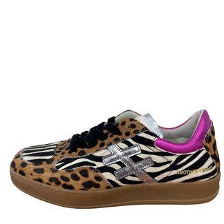 A pair of MOTHER & DOLL low-top sneakers featuring a mixed animal print design with leopard print, zebra print, and black suede, accented with a metallic silver 'X' logo and a bright pink collar, on a white background.