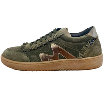Load image into Gallery viewer, An olive green suede sneaker with a metallic bronze side logo and a tan rubber sole, resting on a wooden table against a plain white wall.
