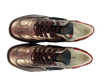 Load image into Gallery viewer, Pair of bronze sneakers on a white surface with a wooden frame background
