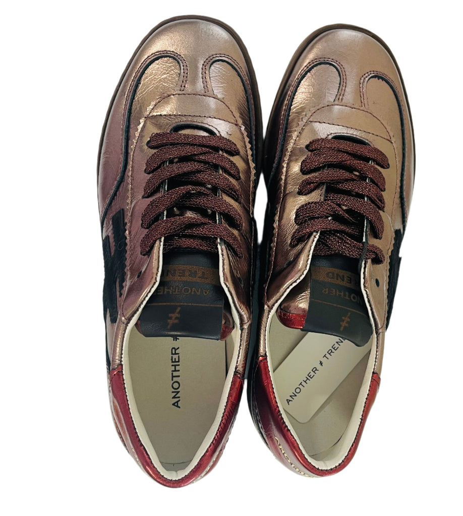 Pair of brown leather shoes on a white surface with wooden sides.