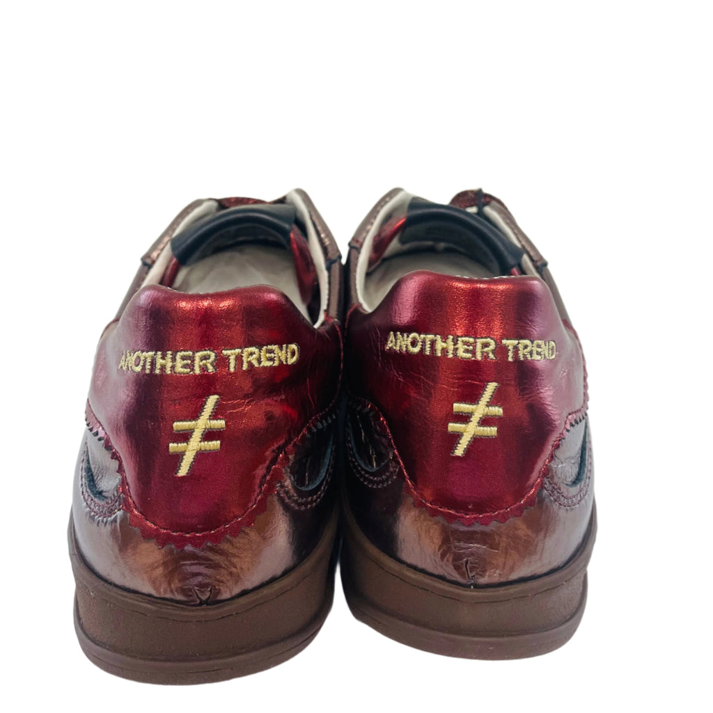 Pair of red shoes with gold text on a white surface