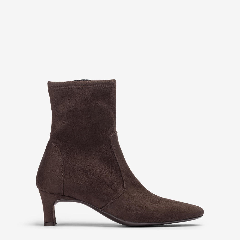 A dark brown suede ankle boot with a pointed toe and a slim kitten heel, shown in profile against a light gray background.
