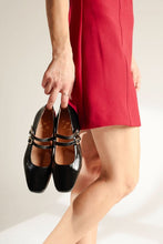 Load image into Gallery viewer, Person holding black shoes with a red dress on a neutral background
