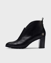 Load image into Gallery viewer, A black leather ankle boot with a chunky block heel, shown from a side profile view against a light gray background.

