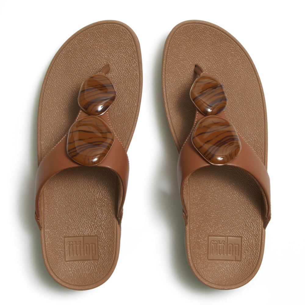 Pair of brown sandals with decorative elements on a white background