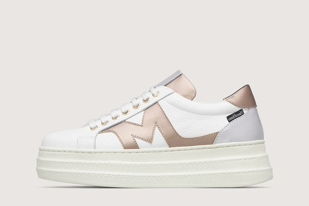 White and beige sneakers with a brand logo on a light gray background
