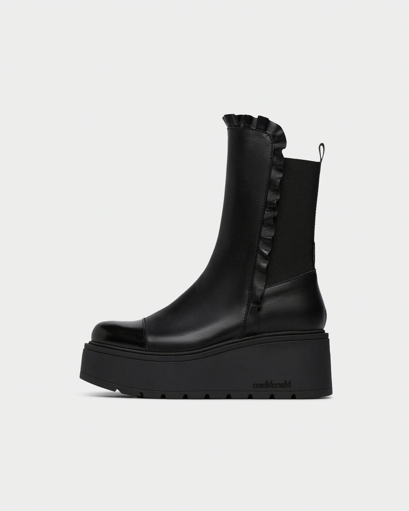 A black leather ankle boot with a chunky platform sole, featuring a ruffled elastic side panel and a small heel pull tab, shown from a side profile on a light gray background.