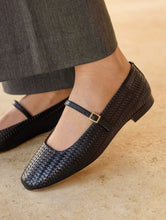 Load image into Gallery viewer, Black woven flats worn with gray pants on a beige surface
