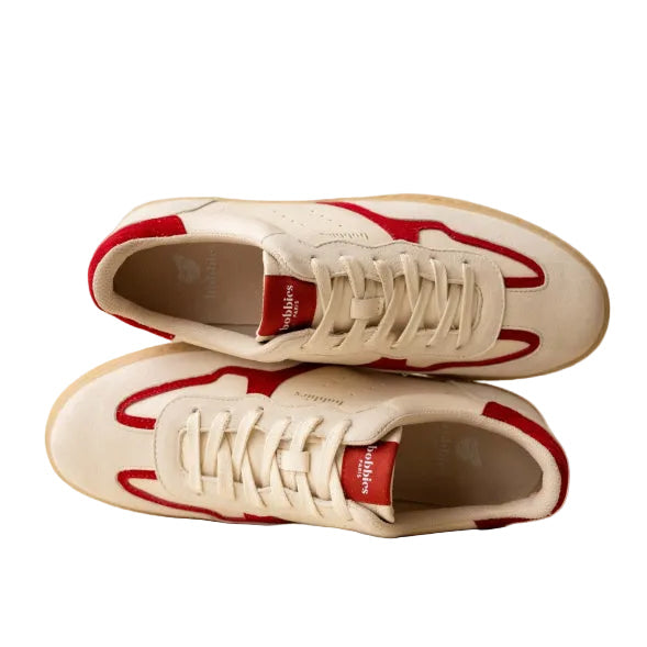 White sneakers with red accents on a beige background