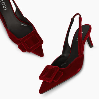A single red velvet slingback high heel shoe with a pointed toe and a small bow detail on the vamp, shown against a plain white background.