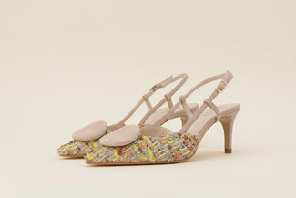Beige high-heeled shoe with colorful sequins on a light gray background