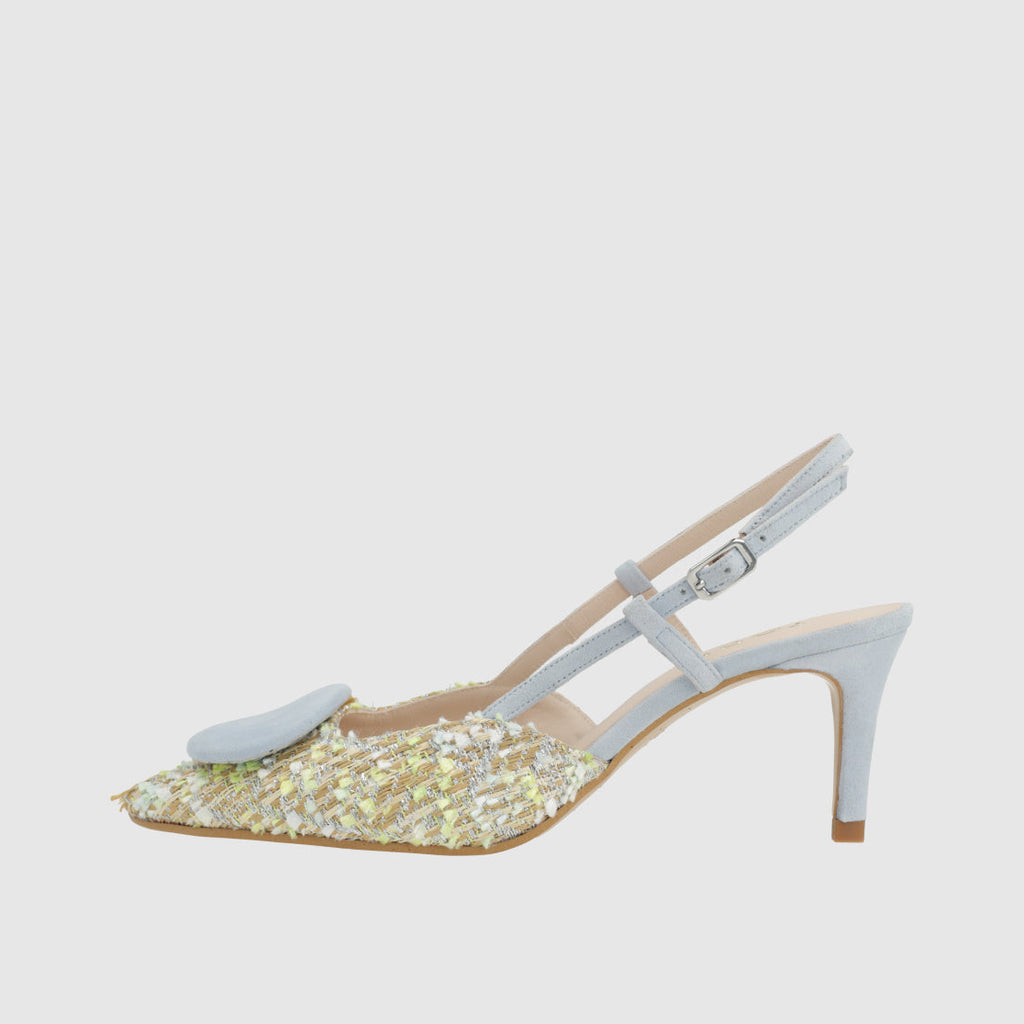 White high-heeled shoe with glittery sole on a light gray background