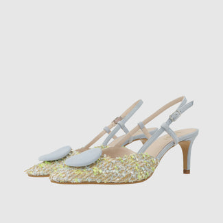 White high-heeled shoe with glittery sole on a light gray background