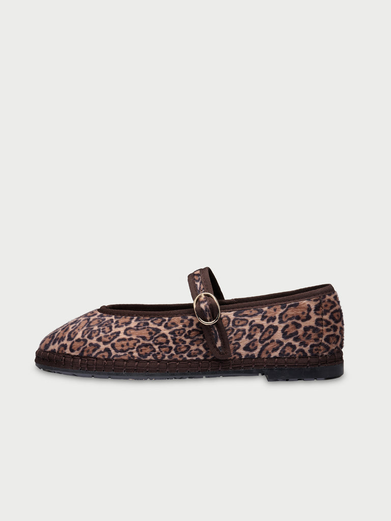 White sneaker with brown sole on a light beige background